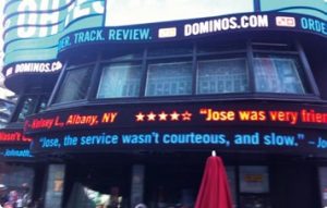 Dominos twitter feed consumer responses on displayed on digital ticker on building