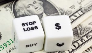 Photo of dice with the word stop and currency symbols
