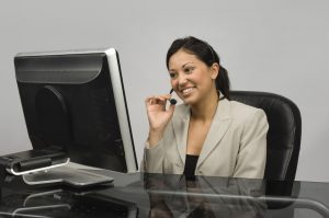 Customer service / sales representative with a headset looking at a monitor