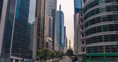 Cars on Road in Between High Rise Buildings