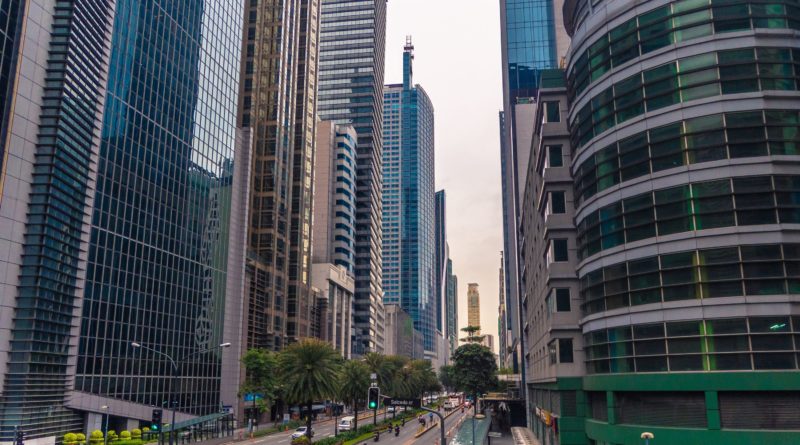 Cars on Road in Between High Rise Buildings