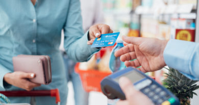 Woman at the supermarket checkout, she is paying using a credit card, shopping and retail concept